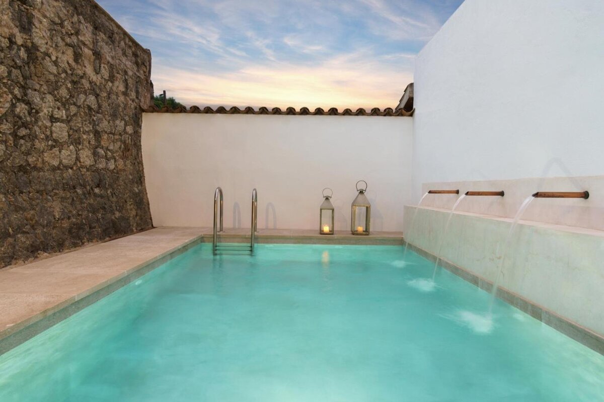 A swimming pool with lanterns on the side of it