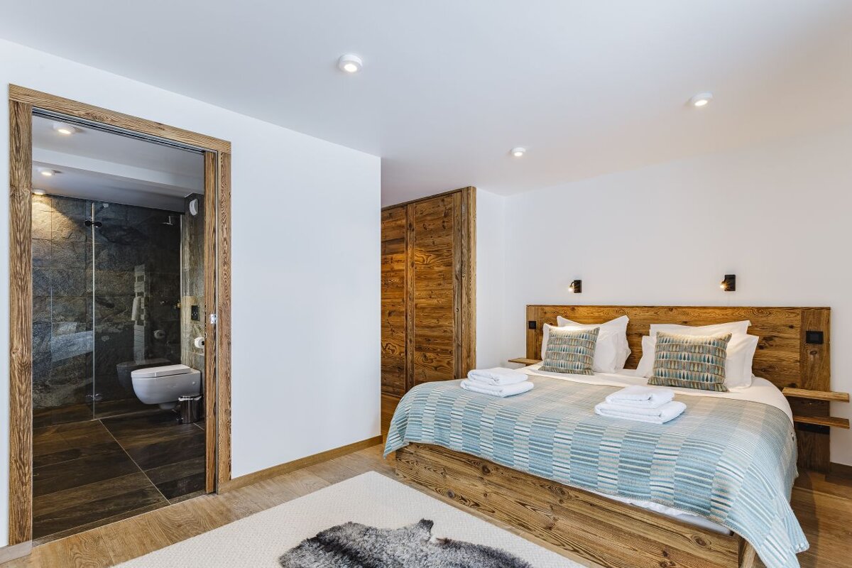 A bedroom with a large bed and a toilet