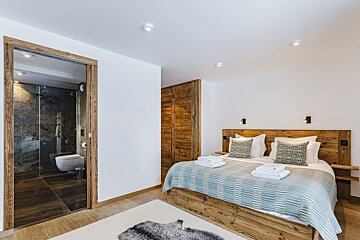 A bedroom with a large bed and a toilet