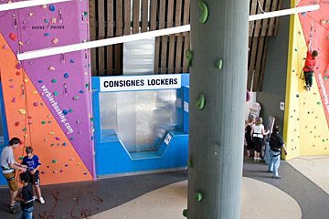 A climbing wall with a sign that says consignes lockers