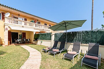 A house with a green umbrella in front of it