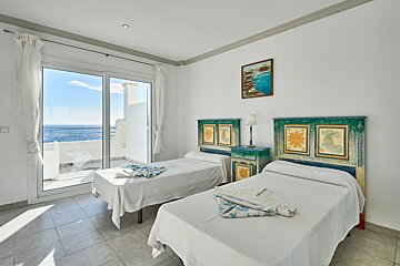 A bedroom with two beds and a picture on the wall