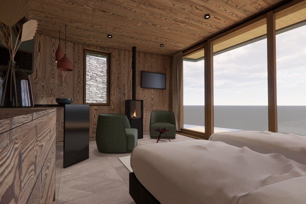 A cozy room with wood walls, a modern fireplace, TV, two green armchairs, and two beds. A large window offers a serene outdoor view.