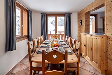 A dining room with a long table and chairs