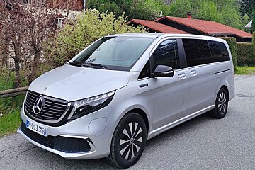 A silver mercedes van is parked on the side of the road