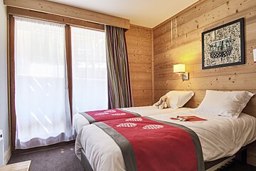 A bedroom with two beds and a picture on the wall that says paris