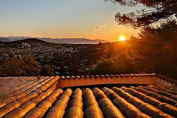 The sun is setting over a city in the distance