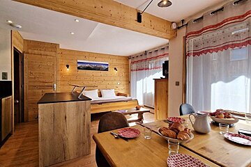 A dining room table with a pitcher of croissants on it
