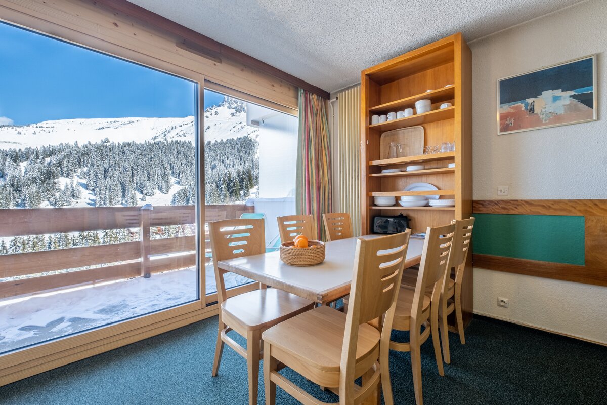 A dining room with a table and chairs and a picture on the wall