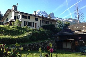 A house on a hill with a mountain in the background