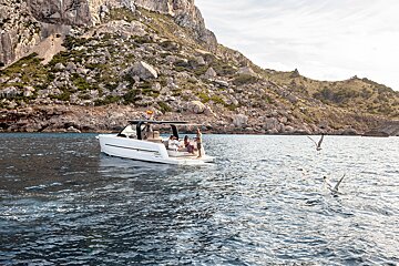 A boat is floating in the water near a mountain