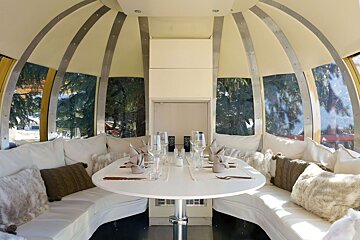 A dining room with a round table and white couch