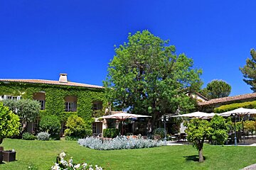 A large house with umbrellas in front of it