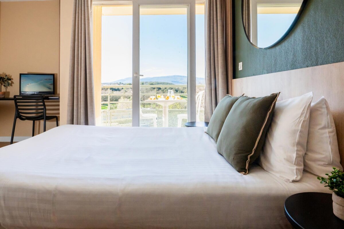 A hotel room with a large bed and a balcony