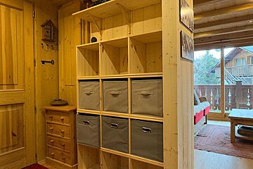 A wooden shelf with gray bins on it