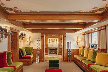 A living room with a fireplace and a painting on the ceiling
