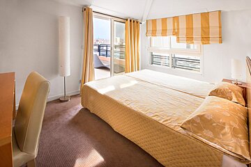 A bedroom with a large bed and striped curtains