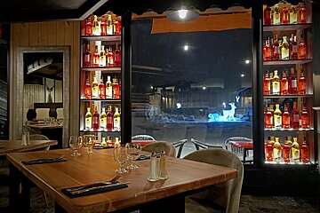 Bottles of wine are lined up on shelves in a restaurant