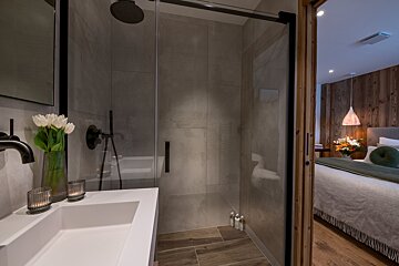 A bathroom with a walk in shower and a sink
