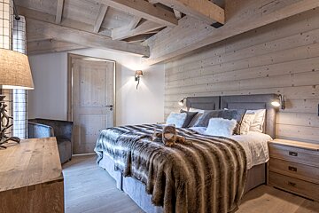 A bedroom with a bed with a fur blanket on it