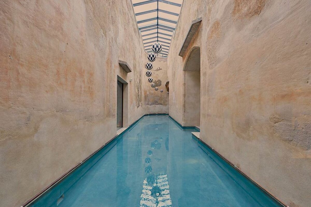 A long hallway with a swimming pool in the middle