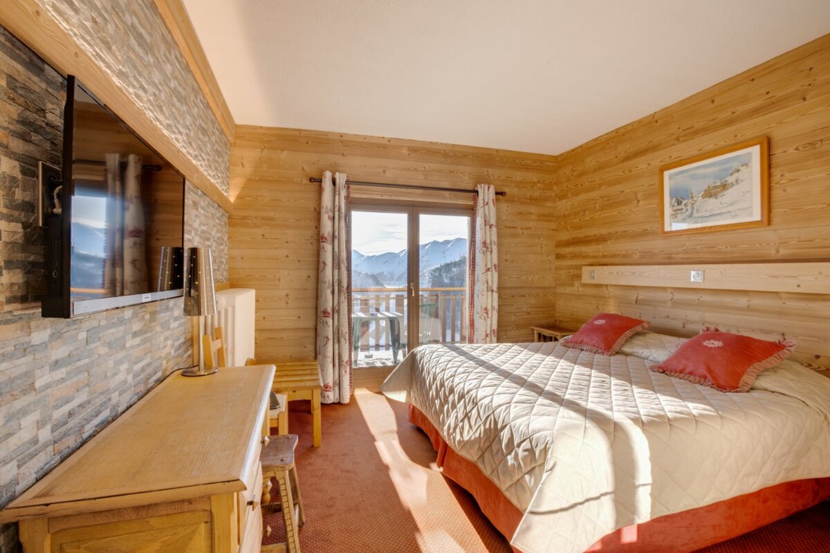 A bedroom with a large bed and a flat screen tv