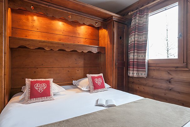 A bed with two pillows and a book on it