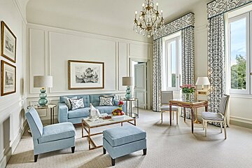 A living room with blue furniture and a chandelier