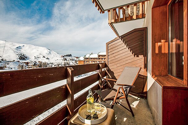 A balcony with a chair and a bottle of lemonade
