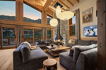 A living room with a painting of skiers on the wall