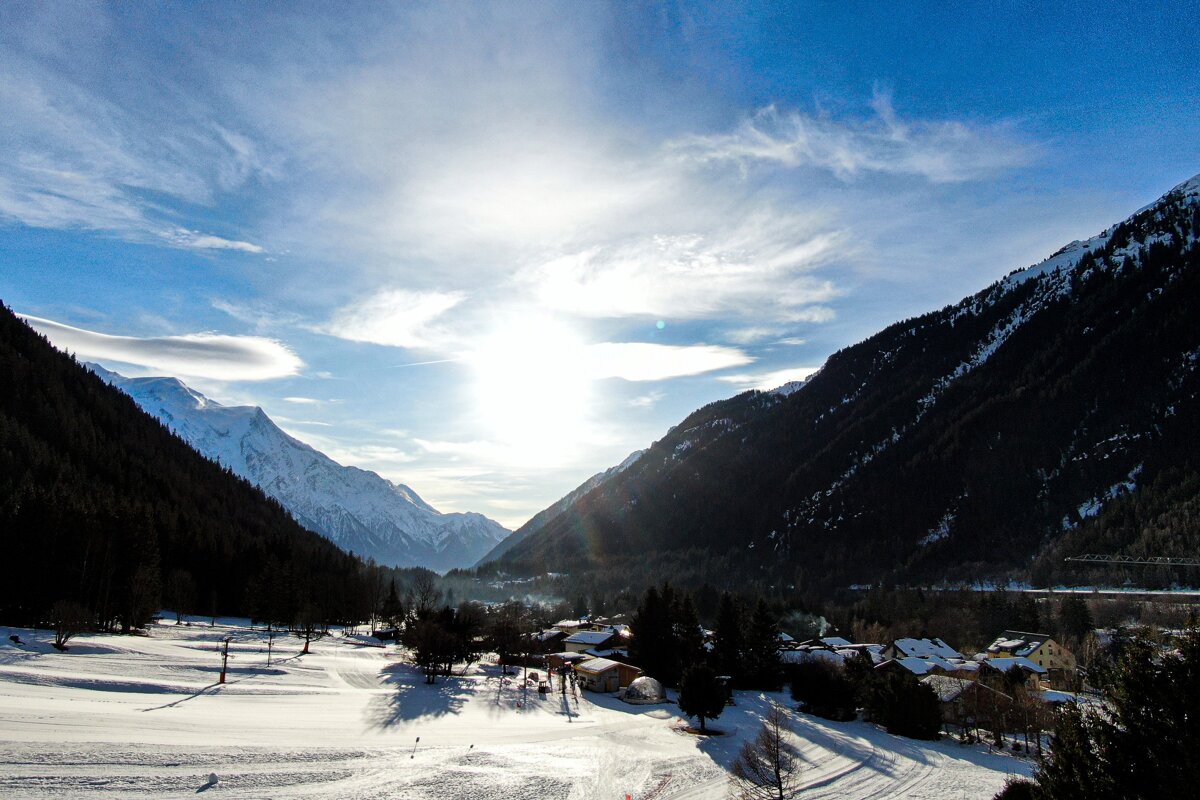 The sun is shining through the clouds over the mountains