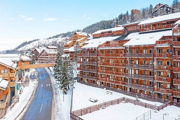 A snowy building with a sign that says ' l' ermitage ' on it