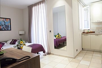 A bedroom with two beds and a large mirror