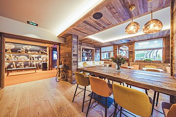 A dining room with a wooden table and chairs
