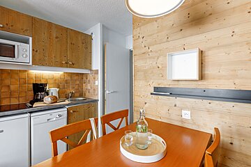 A kitchen with a table and chairs and a microwave