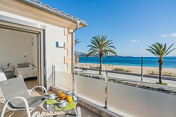 A balcony with a view of the ocean and palm trees