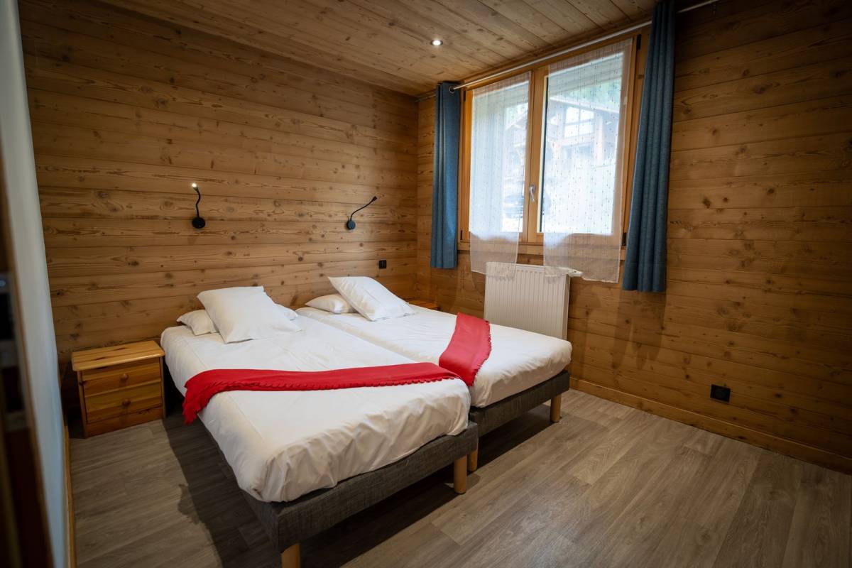 A bedroom with two beds and a window