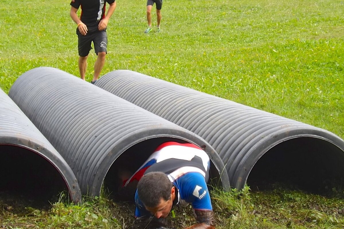 a man crawling through a tunnel on the grass