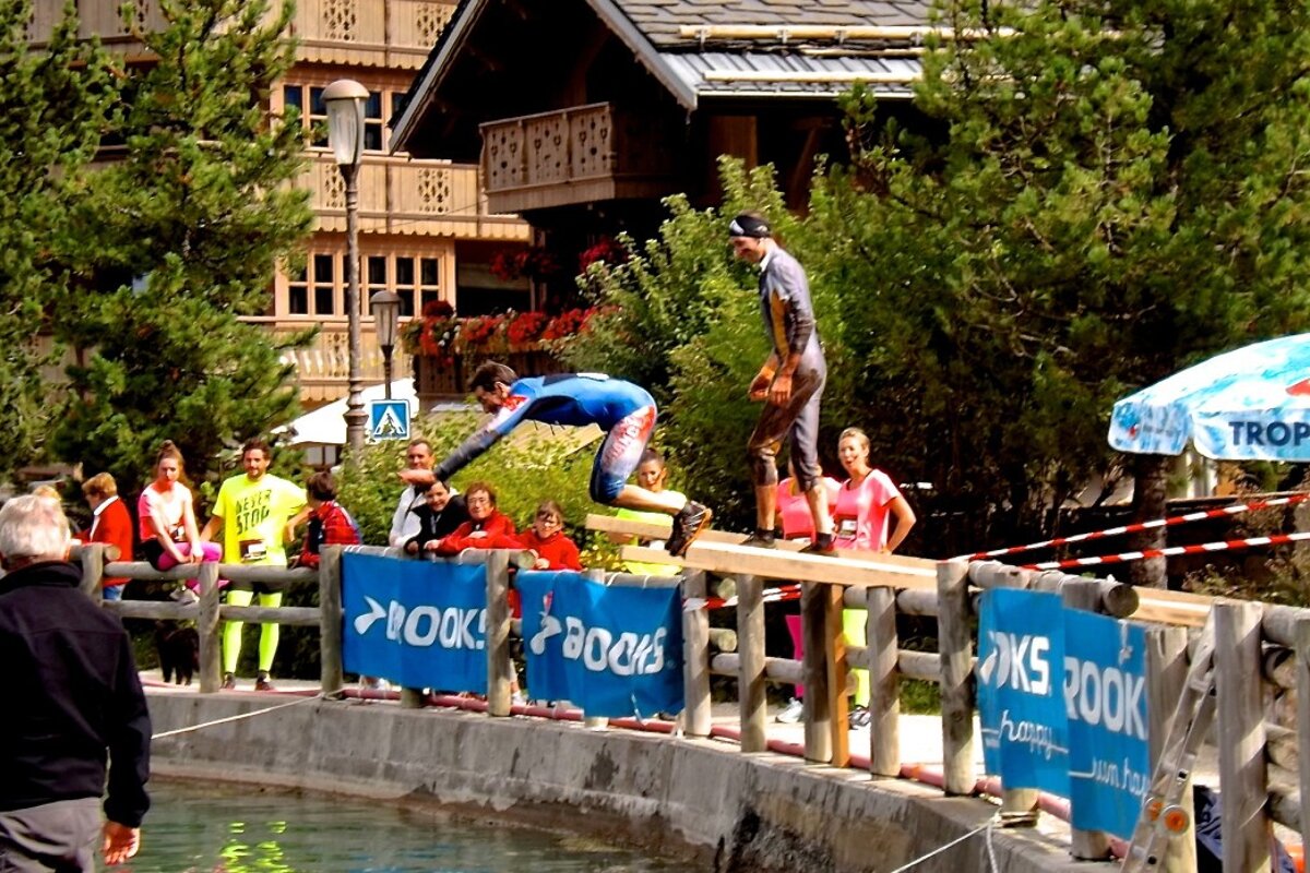 two people diving into the lake in le praz