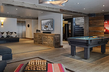 A living room with a pool table and a chess board