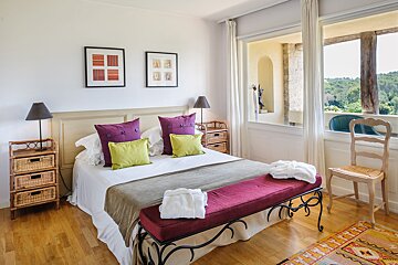 A bedroom with a large bed and a window