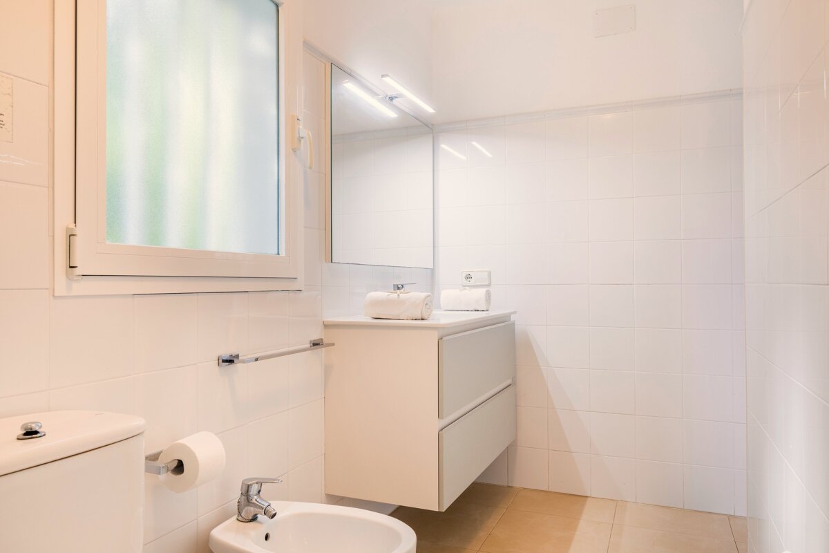 A bathroom with a sink toilet and mirror