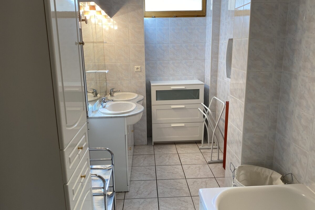A bathroom with two sinks and a towel rack