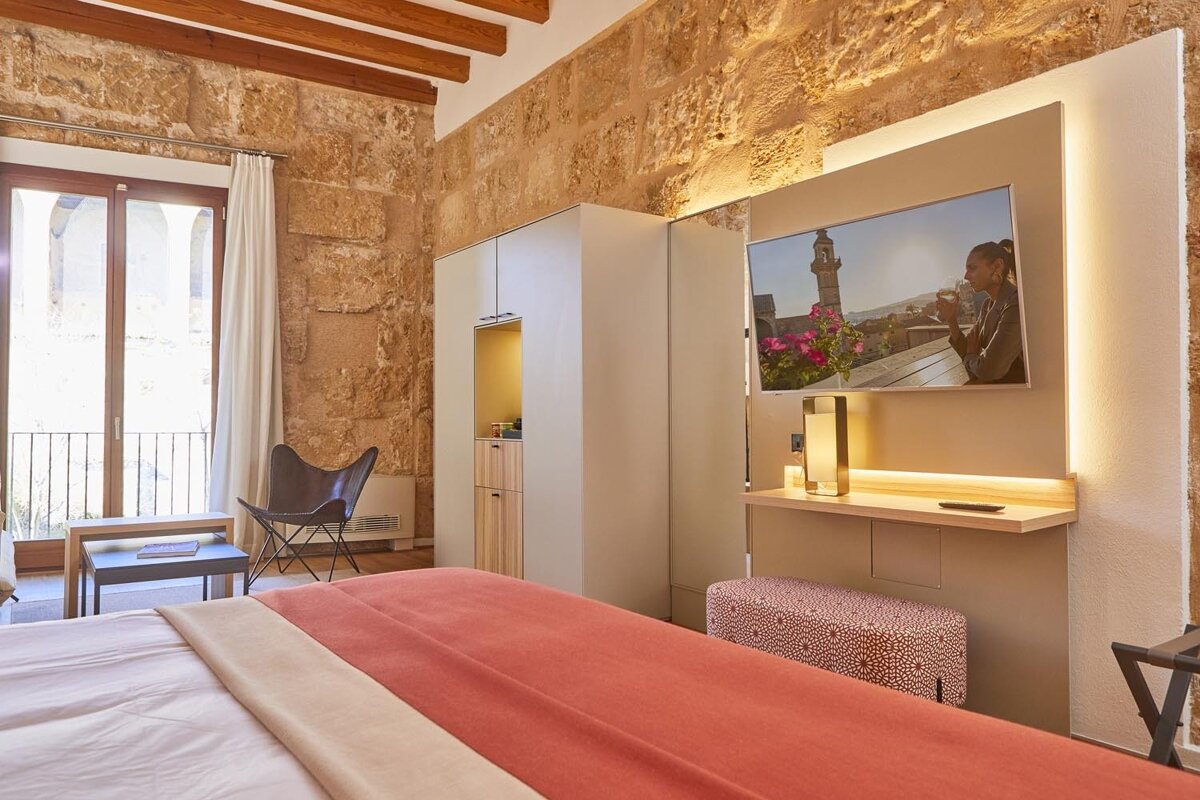 A hotel room with a large flat screen tv on the wall