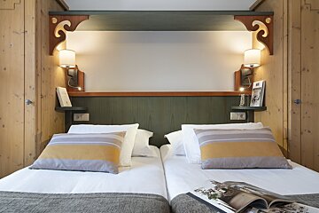 A hotel room with two beds and a magazine on the bed