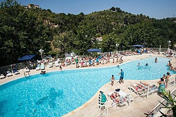 A group of people are swimming in a large swimming pool