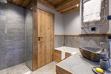 A bathroom with a stone sink and a wooden door