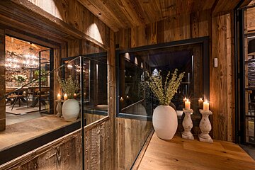 A wooden room with candles and vases on a table
