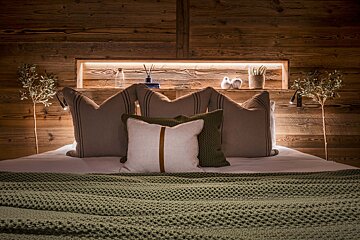 A bed with a wooden headboard and pillows on it