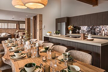 A dining room table with plates and glasses on it